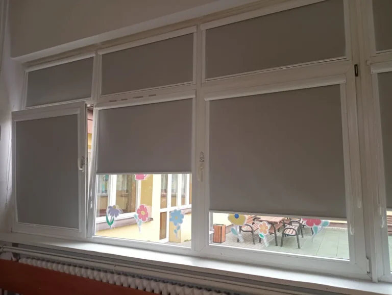 Rolety materiałowe z prowadnicami w szkolnym oknie- Producent rolet Agmart