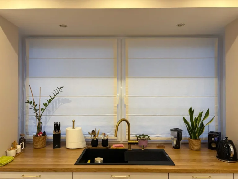 Biała roleta rzymska w kuchennym oknie